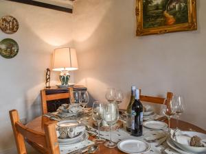 una mesa de comedor con copas de vino y una lámpara en The Old Thatch, en Hailsham