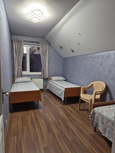 a room with two beds and a chair in it at Guest house in Umanʼ