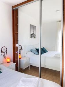 een slaapkamer met twee bedden en een spiegel bij Casa Vane in Santa Coloma de Gramanet