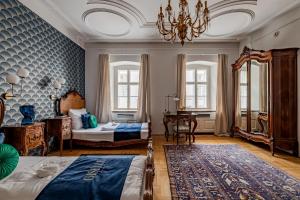 a bedroom with a bed and a chandelier at Giselle Buda Castle in Budapest