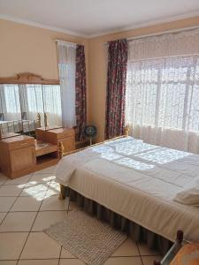 a bedroom with a large bed and a large window at VSA SELF CATERING accommodation unit 2 in Newcastle