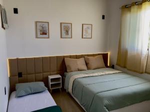 a bedroom with two beds and a window at Chácara Bela Vista in Itajubá +20 photos