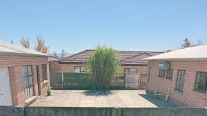 a brick house with a tree in the courtyard at VSA SELF CATERING Accommodation Unit 2 entire house ,Sleeps 4-7 in Newcastle