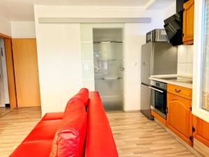 een woonkamer met een rode bank in een keuken bij EG Einzel-Apartment - 24h Check In in Harpendorf