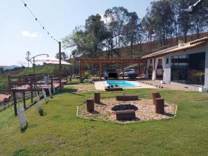 a yard with a swimming pool and a building at Chácara Bela Vista in Itajubá