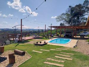 a backyard with a pool and a pergola at Chácara Bela Vista in Itajubá