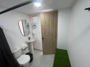 un bagno con un water, un lavandino e uno specchio di Hotel San Gil House a San Gil