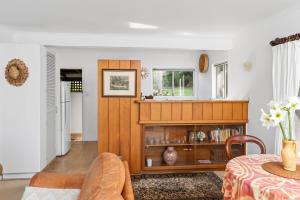 a living room with a book shelf and a table at Selwyn Cottage in Burnt Pine