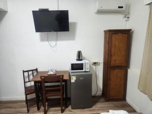 a small room with a table and a microwave and a small refrigerator at Hotel Trinidad Flores in Trinidad