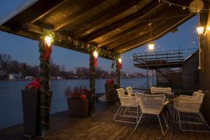 a wooden deck with chairs and a table with lights at Morning Star River Retreat in Belgrade +41 photos
