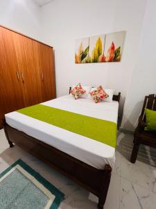 a bedroom with a bed and a painting on the wall at Serenique Greens in Peradeniya