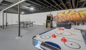Ein Zimmer mit einer Tischtennisplatte und Graffiti an der Wand in der Unterkunft Bellerive Hangout with Hot Tub by StayLage in Fernridge