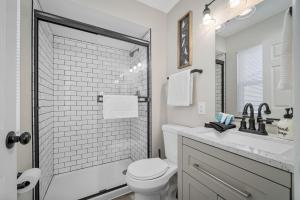 ein weißes Badezimmer mit Toilette und Waschbecken in der Unterkunft Bellerive Hangout with Hot Tub by StayLage in Fernridge + 7 Fotos