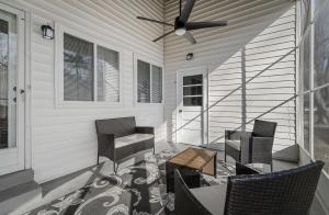 eine Veranda mit Stühlen, einem Tisch und einem Deckenventilator in der Unterkunft Bellerive Hangout with Hot Tub by StayLage in Fernridge