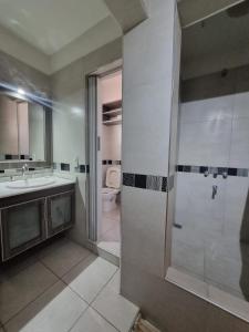 un bagno con doccia, lavandino e WC di La Hélice a Puerto Madryn