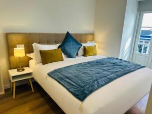 a bedroom with a large bed with blue pillows at Rossio Garden Suites in Lisbon