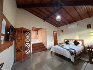a bedroom with a bed and a television and a staircase at Pousada Império in Serra do Cipo +111 photos