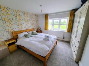una camera da letto con un letto grande in una stanza di Silver Cottage a Scruton