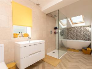 un bagno con lavandino, vasca e doccia di Silver Cottage a Scruton Altre 8 foto