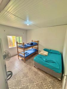 Ένα ή περισσότερα κρεβάτια σε δωμάτιο στο Casa com 2 quartos grandes a 150m da praia