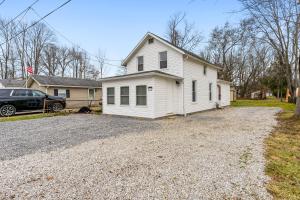 ein weißes Haus mit einem Auto, das in einer Einfahrt parkt in der Unterkunft Lake Milton 3BR Home in Abbeyville
