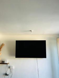 Un televisor de pantalla plana colgado en una pared en Condo at the vineyards, en Kingston