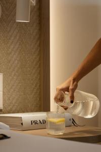 a person pouring something into a glass on a table at Hotel Encinar de Sotogrande in Sotogrande