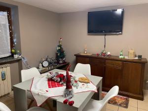 Un comedor con una mesa y un árbol de navidad. en Casa Silvia, en Chambave 5 fotos más