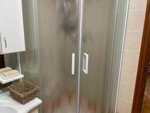 Una ducha con puerta de cristal al lado de un inodoro. en Casa Silvia, en Chambave