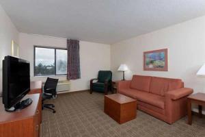 een woonkamer met een bank en een tv bij Norwood Inn & Suites By BlissPoint in Indianapolis