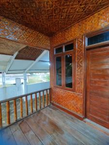 une chambre avec un balcon avec une porte en bois dans l'établissement Villa Sahara Hiil, à Cilauteureun