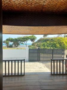 une vue sur l'océan depuis un porche avec deux bancs dans l'établissement Villa Sahara Hiil, à Cilauteureun