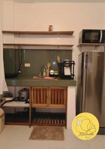 a kitchen with a sink and a refrigerator at Kalachuchi Place by Aman Sinaya in General Luna +11 photos