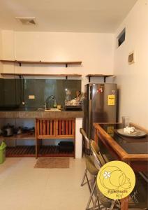 eine Küche mit einem Kühlschrank sowie einem Tisch und Stühlen in der Unterkunft Kalachuchi Place by Aman Sinaya in General Luna