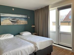 Postel nebo postele na pokoji v ubytování Fijne vakantiehuizen 50 mtr van het strand
