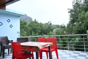 マウント・アブにあるHotel Unique Villaのテーブルと椅子4脚、景色を望むバルコニー