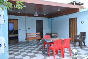 マウント・アブにあるHotel Unique Villaの赤い椅子とテーブルとベンチのあるパティオ