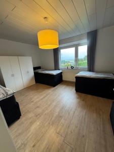 a large room with two beds and a large window at Haus Teveren in Geilenkirchen