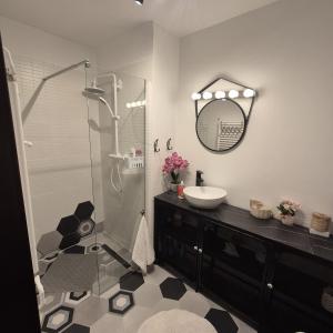 a bathroom with a sink and a shower with a mirror at Mery in Craiova +6 photos