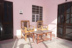 Dos sillas y una mesa en una habitación. en Hotel Karni Niwas, en Jaipur