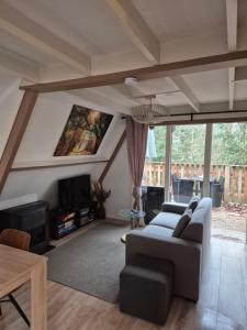 a living room with a couch and a tv at Bois d' Hibou in Durbuy