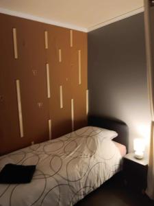 een slaapkamer met een bed met een hoofdeinde en een lamp bij li ptit coeur in Hastière-Lavaux