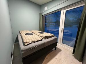 Alpan Apartments, Lyngenfjord في Olderdalen: غرفة نوم صغيرة بها سرير ونافذة كبيرة