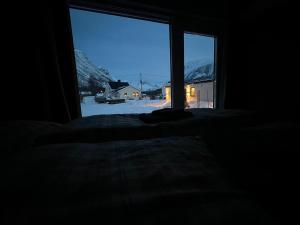 Alpan Apartments, Lyngenfjord في Olderdalen: غرفة نوم مع نافذة تطل على ساحة مغطاة بالثلج
