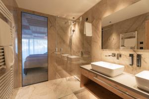 un bagno con due lavandini e un grande specchio di Luxury B&B August a Ortisei Altre 36 foto