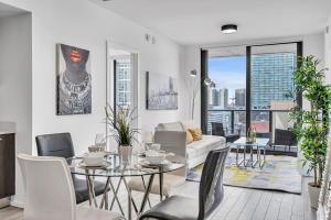 a living room with a couch and a table with chairs at Waterline Corner Vies 2Br 2BA Suites in Miami