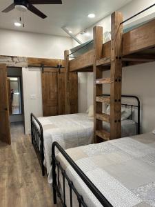twee bedden in een kamer met twee stapelbedden bij Willowbend Bunkhouse 