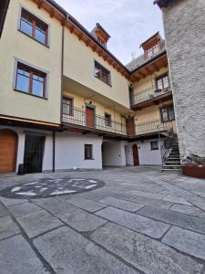 ein großes Gebäude mit Balkonen und einem Innenhof in der Unterkunft Curt di Manai Charme Apartments in Tirano