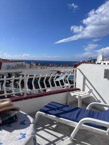 a balcony with chairs and tables and a view of the ocean at Cindy Golden Bay SeaView Terrace in El Guincho