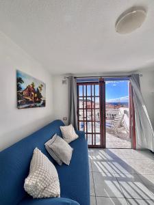 a blue couch in a living room with a window at Cindy Golden Bay SeaView Terrace in El Guincho